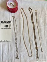 Overview showing four chain necklaces and sterling ring in box