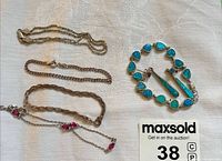 Four silver-tone bracelets and matching turquoise-look dangle earrings laid on cloth surface