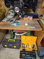 Overall view: radial arm saw on workbench with toolboxes and blades