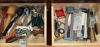 Two drawers with packaged knives, loose knives, honing steel, shears and assorted utensils visible