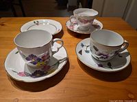 Overview of seven bone china pieces: three teacups, three saucers, one plate
