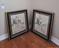 Both framed watercolor paintings leaning against wall