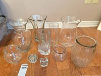 Group of ten clear glass vases, bowls, candle holders on floor