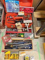 Top view of open red toolbox and wood tray showing majority of hand tools and packaged sets
