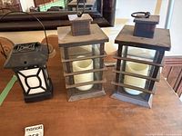 Three lanterns on table, showing overall styles and sizes