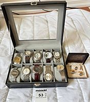 Watch case open showing all wristwatches, tie accessories alongside