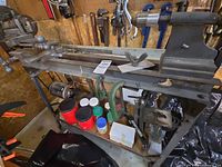 Full view of lathe on stand with accessories and lower shelf contents