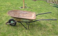 side view of entire metal wheelbarrow showing tray, wheel and handles
