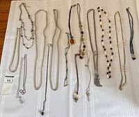 Overview of 13 necklaces laid out on white background