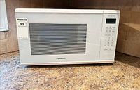 Front view of Panasonic white countertop microwave showing door, window, control panel