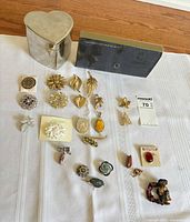 Entire lot laid out showing all jewelry pieces, heart-shaped box and jewelry wallet