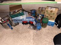 Group shot of assorted boxed and loose plumbing hardware including ball valves, Moen box and fittings