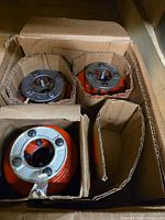 Three Ridgid die heads stored in corrugated dividers inside box