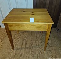 Angled full view of side table showing top, legs, and finish