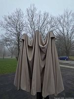 Closed beige canopy on black pole