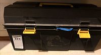 Front view of black toolbox showing yellow latches and blue cord
