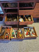 Cabinet with six drawers open showing assorted hand tools, reflectors, hex-keys, clamps and packaged items