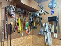 Overall view of pegboards showing levels, clamps, brushes, clock and other tools