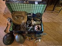 open trunk showing contents and external helmets, belts and ordnance