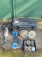 Milwaukee sander/grinder, toolbox, several abrasive discs arranged outside