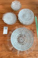 Group view showing all pressed glass items: serving bowls, platter, plate stacks and berry bowls