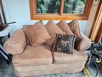 Front view of one loveseat with four back cushions and accent pillow