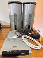 Lot overview showing two Centrios speakers, D-Link modem, transmitter base, cables and power adapter