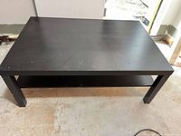 Top view of black espresso coffee table showing surface wear and overall shape