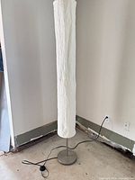 full view of lamp standing in corner showing shade and base