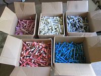 Five open boxes containing perm rods in assorted colours