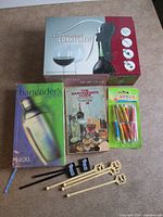 All items overview: wine opener set box, two books, pack of umbrellas, assorted stirrers