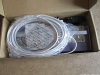 Box containing coiled white coaxial cable and components
