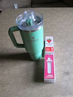 Insulated mug with one flavor cartridge beside it