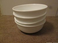 Four stacked white Corelle bowls side view