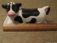 Cow-shaped butter dish with ruler for scale