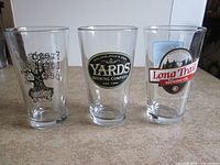 Front view of three brewery pint glasses