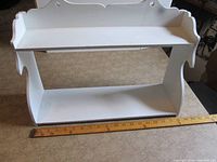 Front view showing two tiers, curved sides, scalloped top
