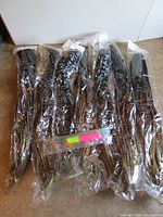 Seven sealed packages of braided hair extensions laid out