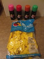 Bag of yellow balloons and four Crazy String cans