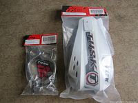Sealed packages of Tusk hand shields and brackets