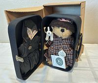 Open travel trunk showing bear, dog plush and extra outfit
