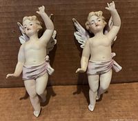 Front view of both bisque cherub wall hangings