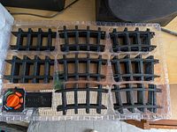 Tray showing nine curved track pieces and controller