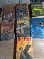 Seven Harry Potter hardcovers with jackets laid out on table