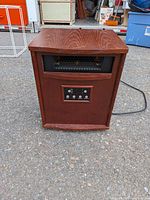 Front view of wood cabinet heater showing grille and control panel