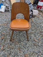 Front view of wood chair with orange vinyl seat