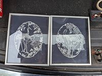 Both framed artworks side by side in vehicle trunk
