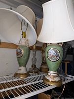 Both matching porcelain lamps with shades on shelf
