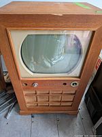 Front view of RCA Victor console TV showing round screen, speaker grille and cabinet condition