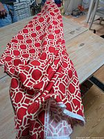 Fabric roll showing red and white geometric pattern and selvage